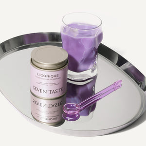 Ube latte violet préparé avec L'Iconique Seven Taste, servi sur plateau miroir avec cuillère violette