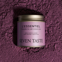 Boîte de poudre de ube signature Seven Taste « L’Essentiel » sur fond de poudre de ube violette, superaliment naturel aux notes de vanille et noisette.