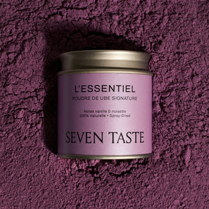 Boîte de poudre de ube signature Seven Taste « L’Essentiel » sur fond de poudre de ube violette, superaliment naturel aux notes de vanille et noisette.